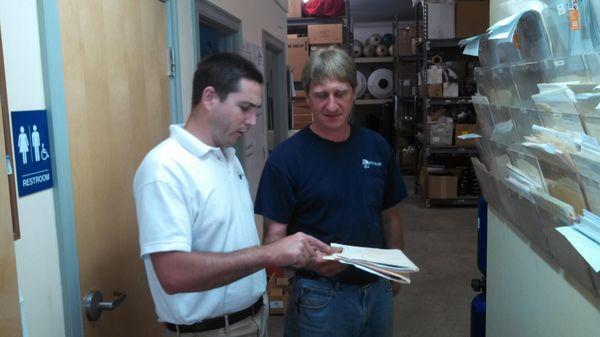 Senior sales tech David Watts and Master Plumber / Service Technician Scott King reviewing a customers water test results.