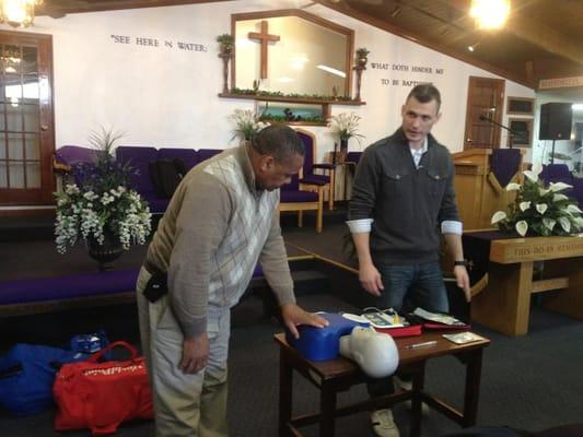 Owner Andrew Berger talking with a parishioner of a Milwaukee church about how to properly use an AED (Automated External Defibrillator).