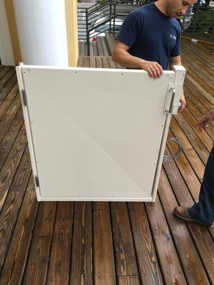 employee holding up a VPL (wheelchair lift) door for installation