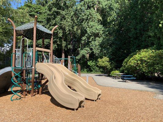 Playground with two picnic tables nearby