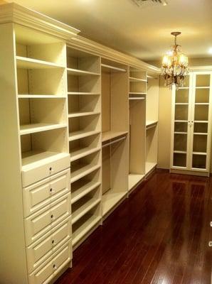 Almond walk-in closet  with crown molding, raised panel drawer fronts, adjustable shelving & hanging space.