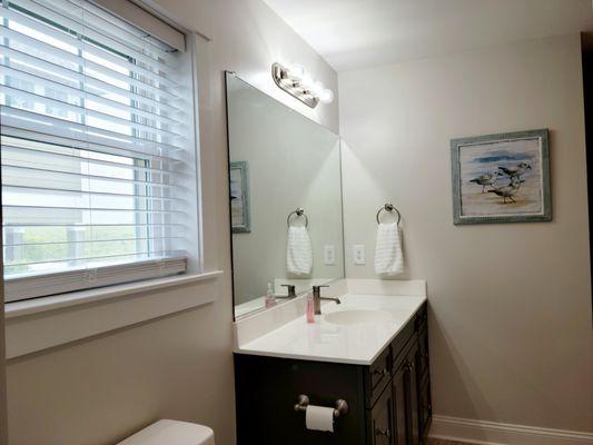 Downstairs king sized bedroom bathroom with  vanity, tub/shower, and toilet.