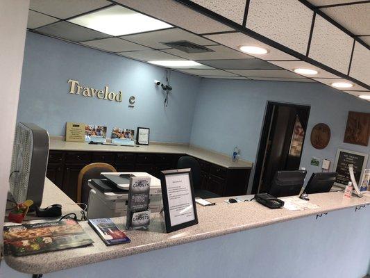 Front desk with no employees in sight. Hotel logo behind the desk is falling apart just like the rest of the property