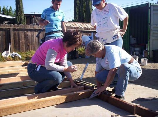 Diane teaching a volunteer to frame a wall.