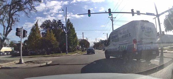 The driver beginning to make a left turn from the right lane, as the stoplight turns green.