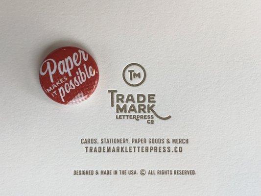 The back of one of our cards and our little 'Paper makes it possible.' promo button.