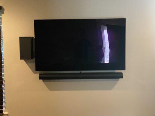 Mounted TV, sound bar, and Xbox