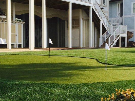 ForeverLawn synthetic landscape grass and a putting green provide low maintenance for this beachside residence.