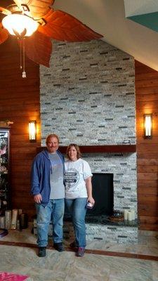 Owners Joe and Mary Jo Ward in front of a fireplace re-faced with recycled granite tile