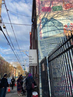 photo of the outside of our building when coming towards it from the west side of the street featuring "Illumination Lights the Way" mural