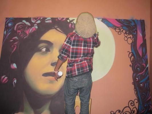 Aise puts the finishing touches on his mural of Annabelle.