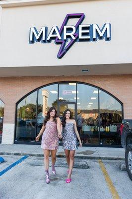 The two owners in front of their flagship storefront with MAREM logo.