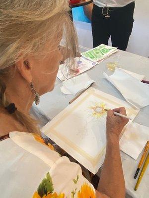 Sally Wilson shows students how to paint a flower in watercolor in a one session workshop for beginners.