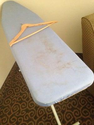 Dirty ironing board. Everything in the room is dirty.