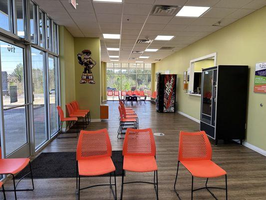 Spacious waiting area with TVs and vending machines