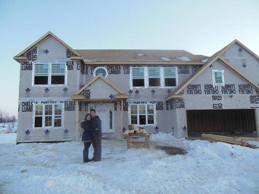 Buyers relocating from Virginia posing after signing the paperwork to buy their new home outside of Ann Arbor.