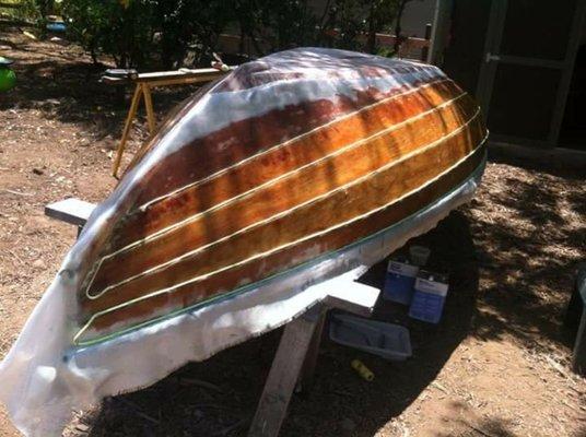 Adding a sheathing layer of fiberglass to a lapstrake planked hull.