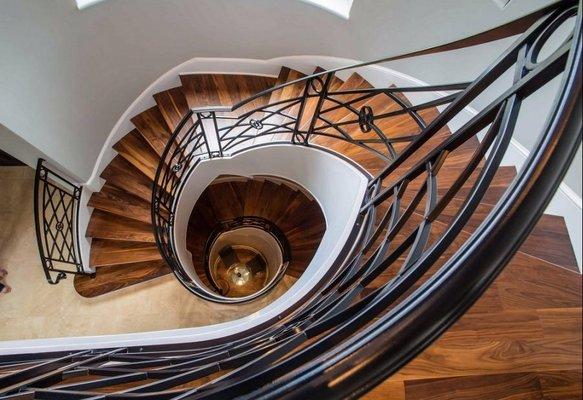 View of a continuous curved staircase from the second floor to the basement; built and installed by Andronx stair company.