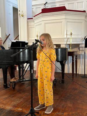 One of our younger voice students performing at a recital.