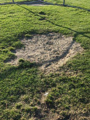 Dirt in front of the backstop. That's where home plate could be