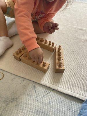 Knobbed cylinders help the child have a tangible experience with dimensions and size variation,