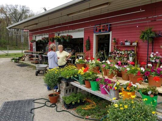 Sue and her team like to display their flowers and other goods, and they like to greet their customers.