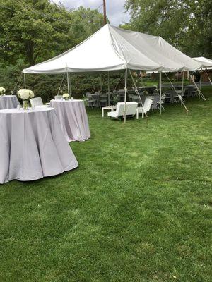 Birthday party with a 20x40 grass tent and a 10x20 frame tent kick-out with cocktail tables and silver linens.