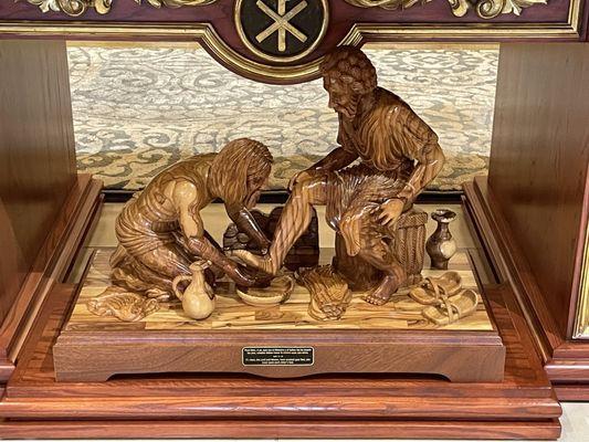 Wood sculpture of Jesus washing Disciples' feet.