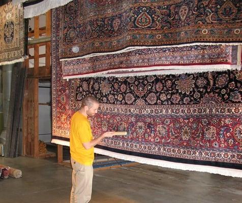 Hand brushing a rug in order to insure that the fibers are aligned correctly