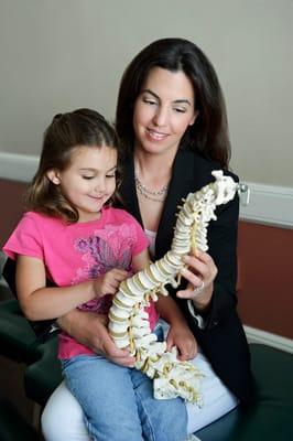 Dr. Dina educating her young patient about spine health.