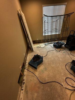 Drying after carpet and damaged baseboard removal.