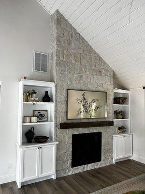 Installed electric fireplace, mantel, stone and cabinetry.