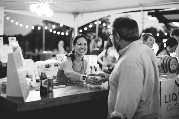 A Liquid Catering bartender serves a guest