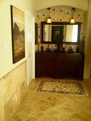 Travertine tile. Customer vanity cabinet with custome finish. Arched opening.