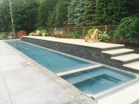 This lap pool features an attached spa with an automatic retracting cover.