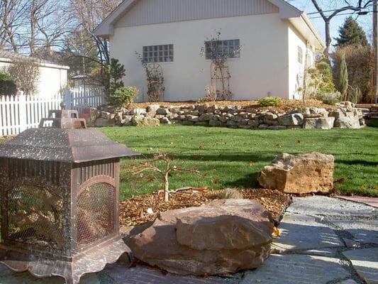 Regrading backyard, use of tons of natural stone, play area and patio space