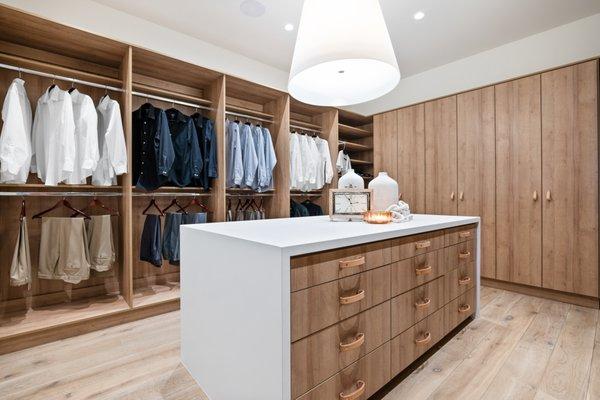 Wood Grain Luxury Closet W/ Leather handles & tabs alongside a quartz countertop island