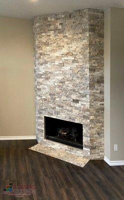 Stone fireplace installation with vinyl plank floors.