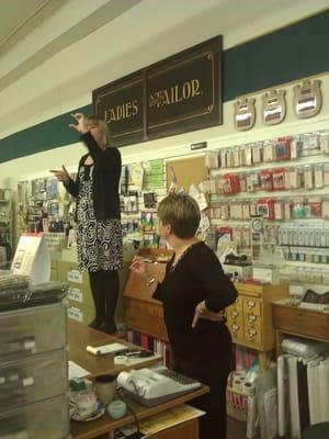 The girls are giving customers on the bus trip the layout of the store.