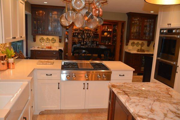 White Painted Shaker Cabinets, Cherry Wet Bar and China Cabinet as well as Hickory Pillars all provided by Anderson Amish Cabinets