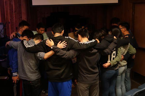 College students praying together at a Fall retreat in Redwoods.