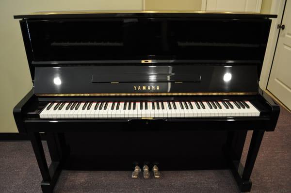 Yamaha professional upright piano in high gloss black.