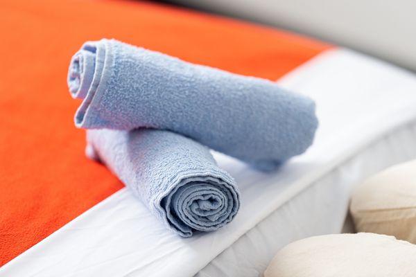 Prepared for Relaxation: Neatly rolled towels await Massage by Monique's guests, promising comfort and care.