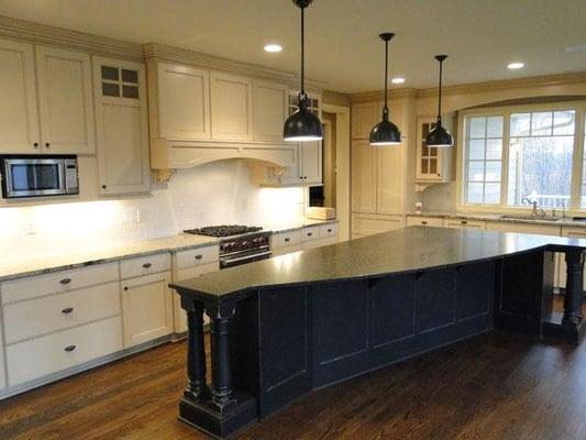 Enameled kitchen cabinetry and black enameled center island with rub through.