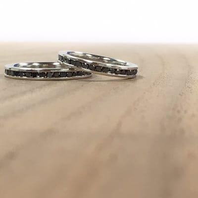 A matching set of platinum and black diamond eternity bands.