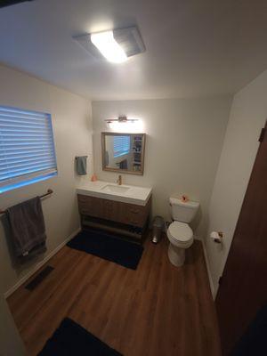 Bathroom created from laundry room by moving water heater and adding a shower, toilet, vanity, closet, flooring and paint.