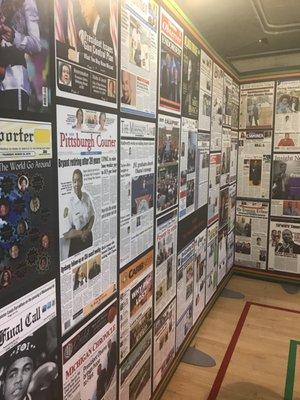 Wall of black newspapers and notable headlines.