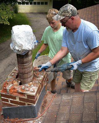 Sid (owner) teaching repairs to his grandson Troy during a repair job.