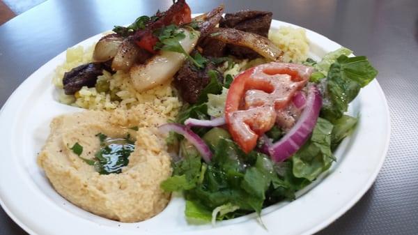 Shish kebab plate with salad, rice and hummus