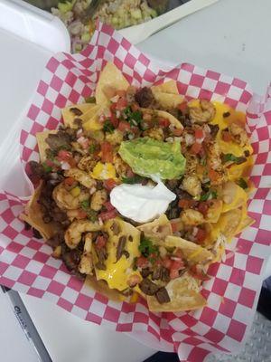 Steak and shrimp nachos with homemade nachos chips  fresh guacamole sirloin steak and grilled shrimp.